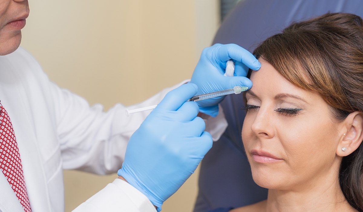 Dr. Vu Demonstrating Injecting Filler Into Patient's Forehead