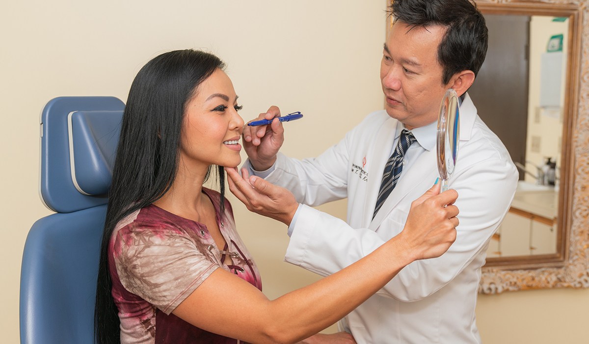 Dr. Vu Using Marker On Female Patient's Face During Consultation