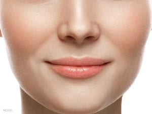 Closeup portrait of female nose and mouth on white background